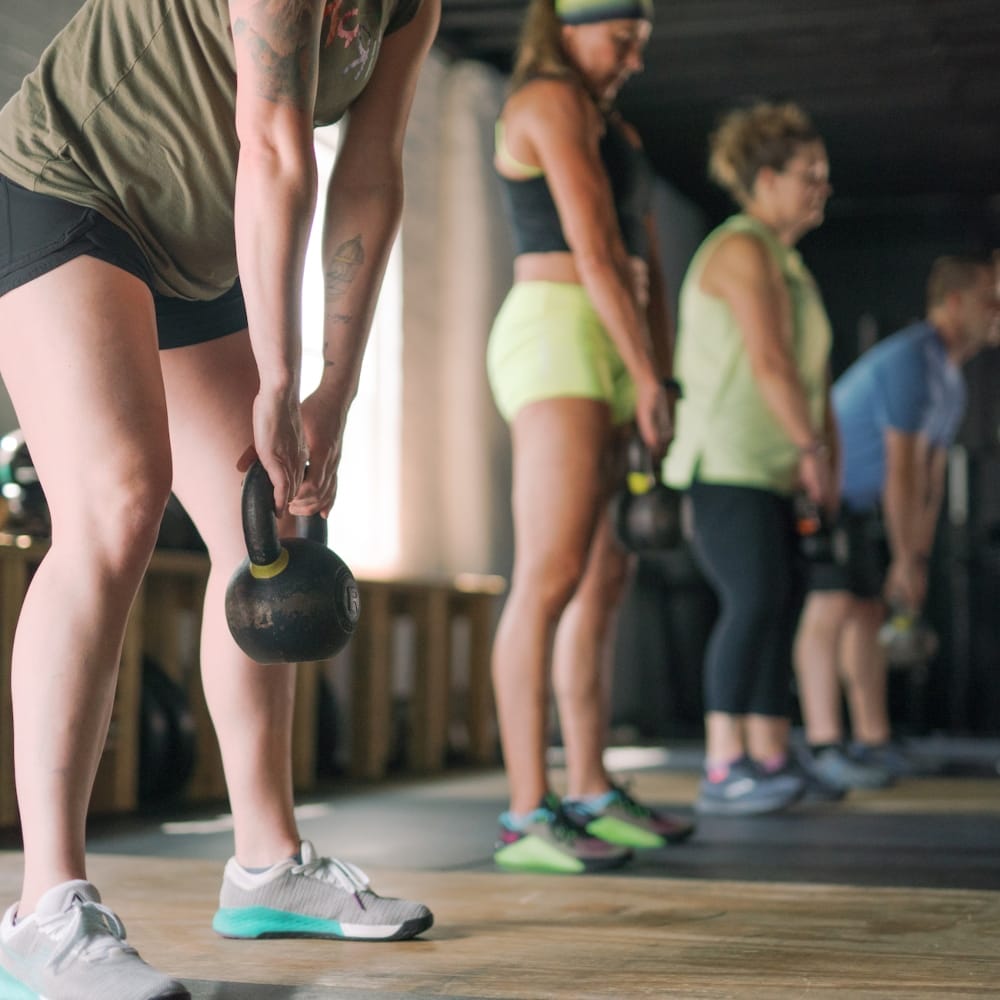 Four women holding kettlebells in workout class